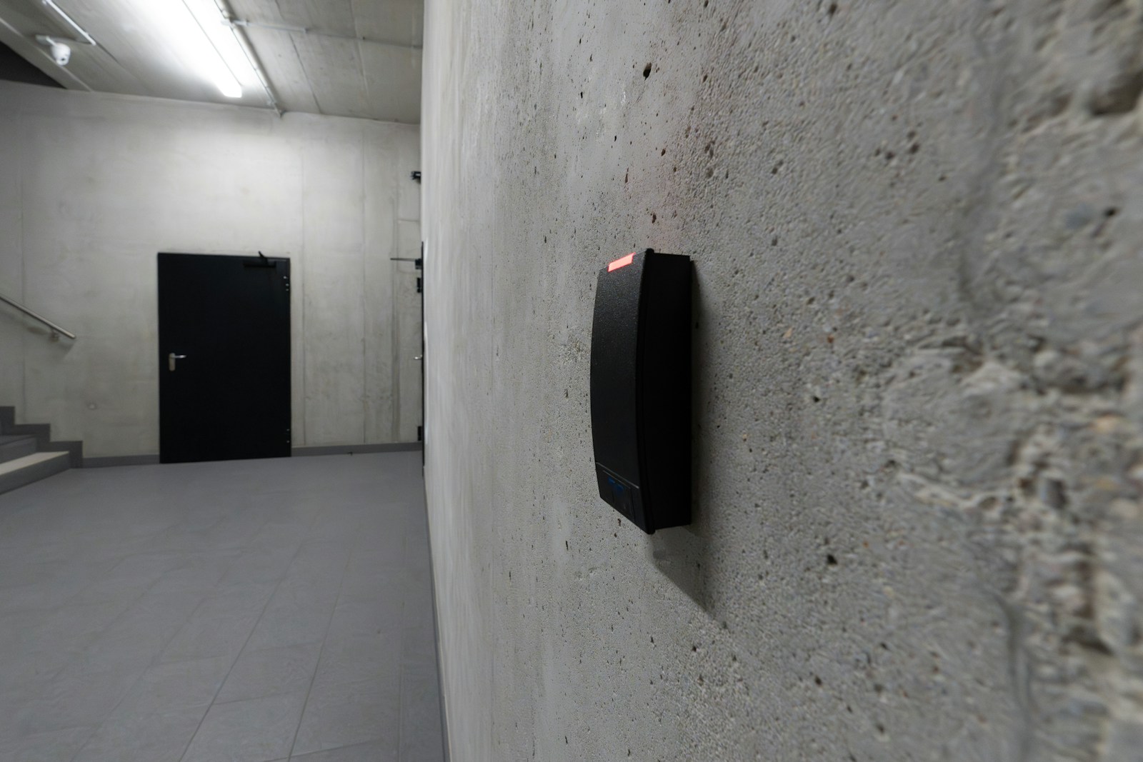 Wall-mounted attendance reader beside an office door